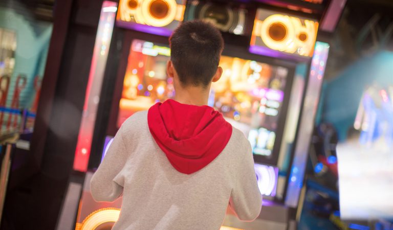 A boy dancing with game arcade machine in selective focus. A boy dancing with game arcade machine in selective focus.